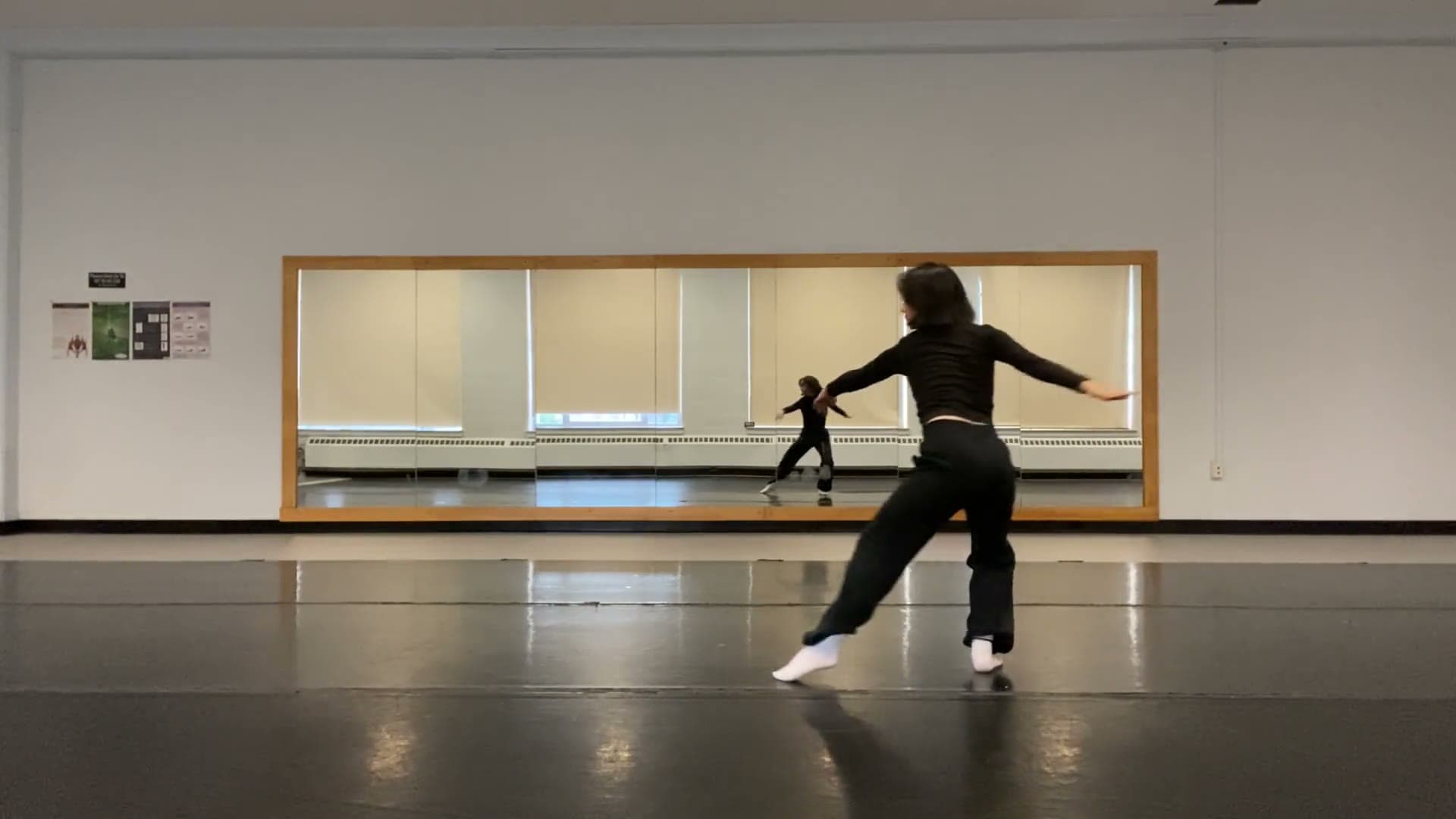 May Rhoda Saito dancing in a mirrored studio.