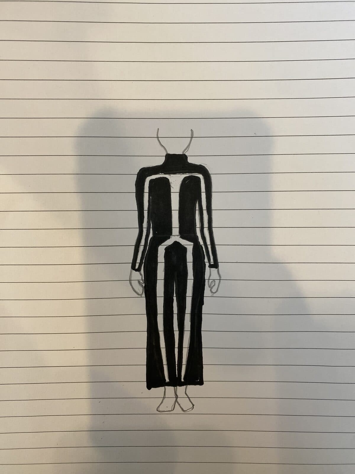 A drawing on lined paper of a figure in a black bodysuit marked with white stick-figure lines.